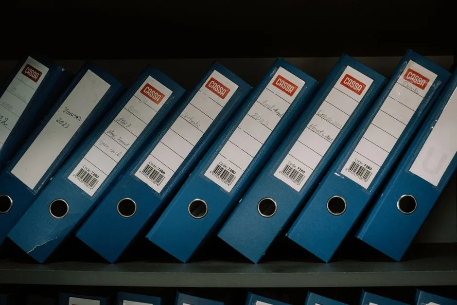 Rows of labeled document binders on office shelving, illustrating organized public-records archives